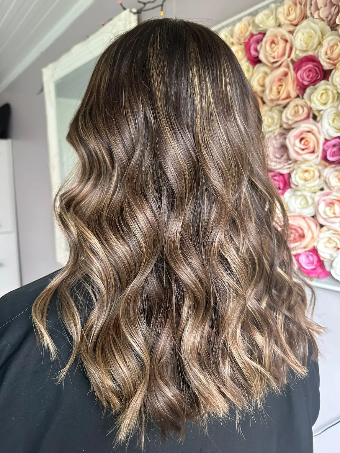 Long brunette hair with lighter strands and loose waves